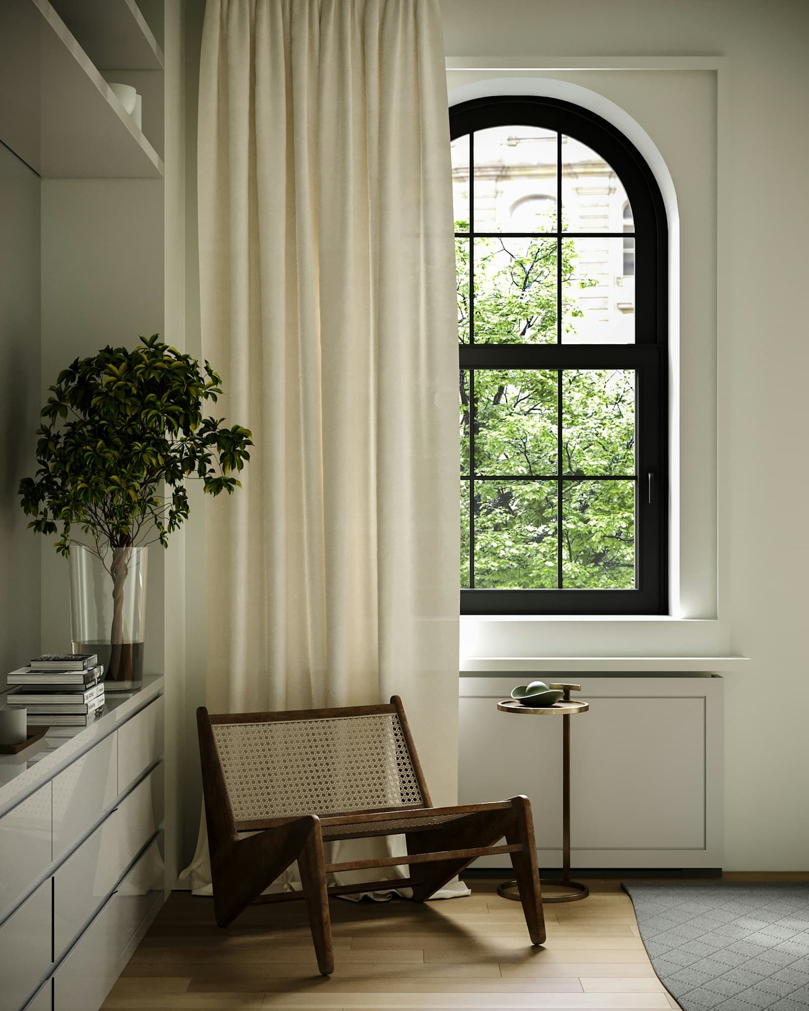 Tall arched black-framed window beside a full-height ivory linen curtain, with a cane-backed lounge chair, a potted tree and a pale timber floor